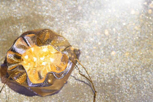 Golden sack filled with glowing treasures illuminated by glittering light