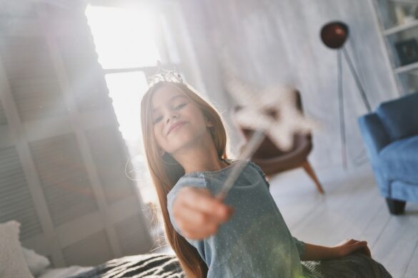 Real princess. Cute little girl playing with a magic wand while spending time at home
